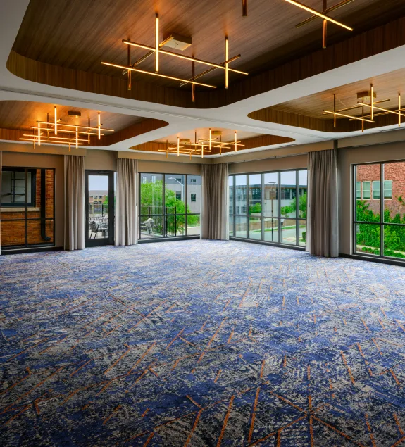 Meeting & Event Space at The Nobleman Hotel in Fort Worth, TX with Modern Lighting, Floor to Ceiling Windows and Adjoining Outdoor Patio.